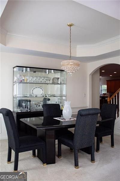 dining area with ornamental molding and a chandelier