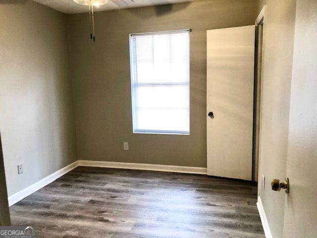 unfurnished room featuring dark hardwood / wood-style floors and ceiling fan