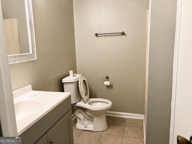 bathroom with tile patterned flooring, vanity, and toilet