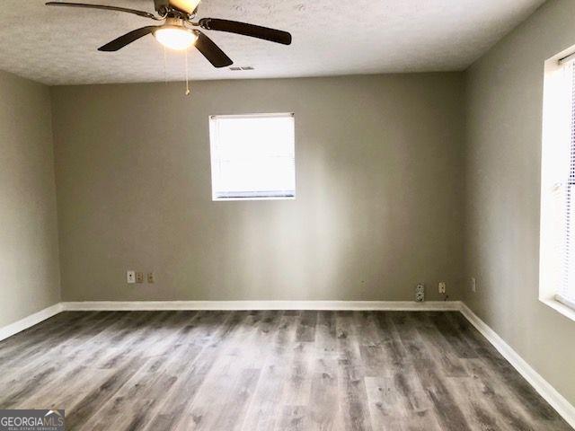 spare room featuring hardwood / wood-style flooring, plenty of natural light, and ceiling fan