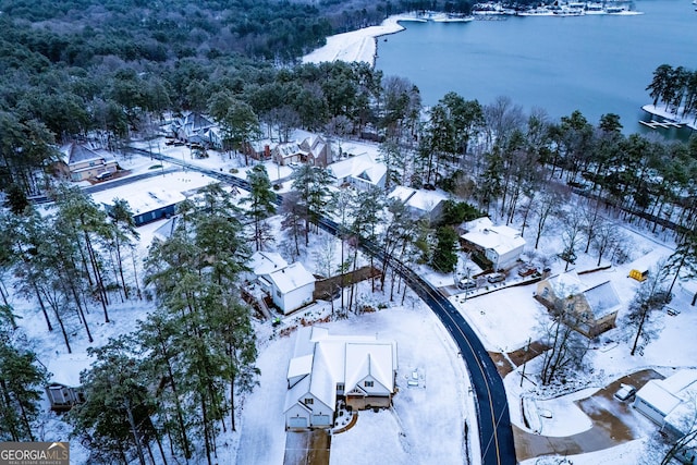 snowy aerial view with a water view