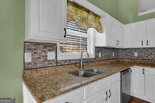 kitchen with tasteful backsplash, dark stone countertops, white cabinetry, and sink