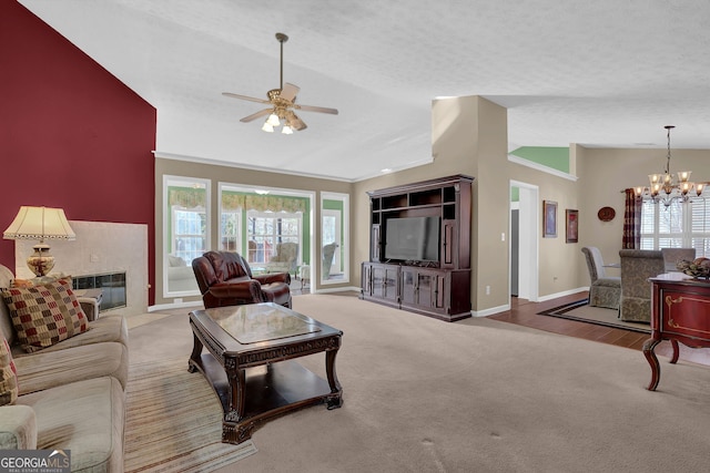 carpeted living room with a textured ceiling, ceiling fan with notable chandelier, a wealth of natural light, and lofted ceiling