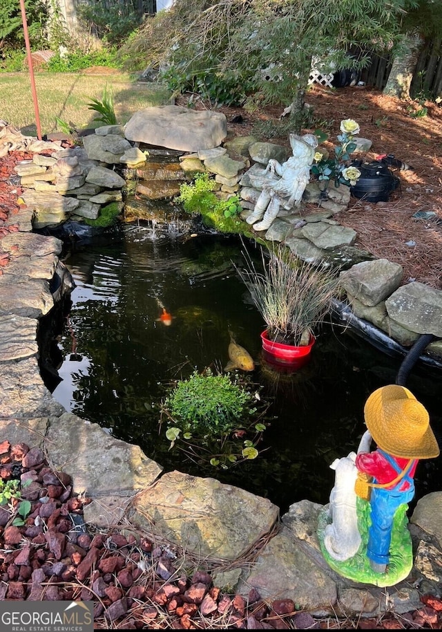 exterior details with a garden pond