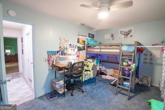 carpeted bedroom featuring ceiling fan and a textured ceiling