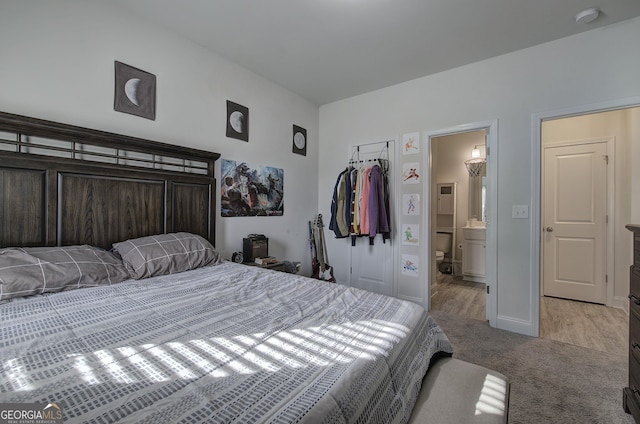 carpeted bedroom with ensuite bath and a closet