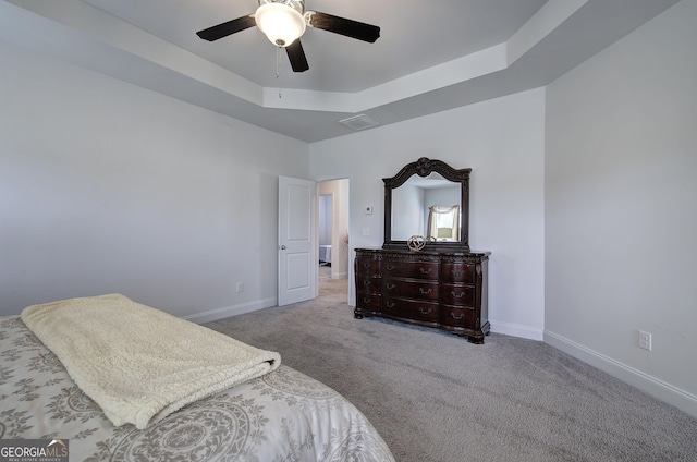 bedroom featuring ceiling fan, a raised ceiling, and carpet floors