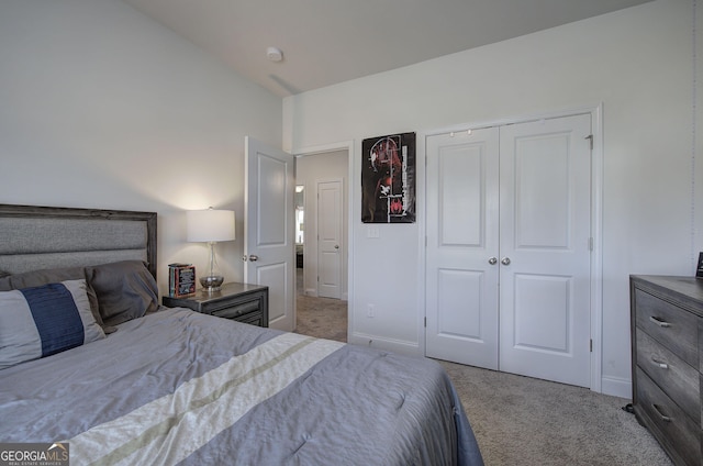 carpeted bedroom featuring lofted ceiling and a closet