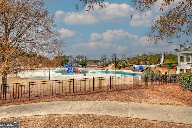 view of swimming pool featuring a water slide and a playground