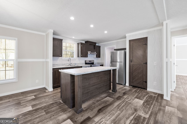 kitchen with dark hardwood / wood-style flooring, stainless steel appliances, a kitchen island, and plenty of natural light