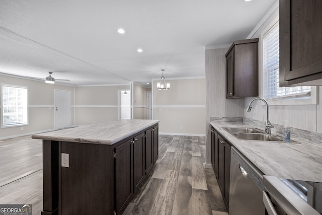 kitchen with sink, stainless steel appliances, hardwood / wood-style flooring, a kitchen island, and ornamental molding