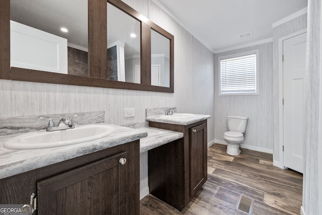bathroom with vanity, hardwood / wood-style flooring, toilet, and ornamental molding