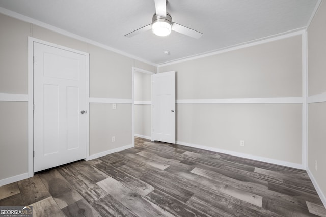 unfurnished room with ceiling fan, dark wood-type flooring, and ornamental molding