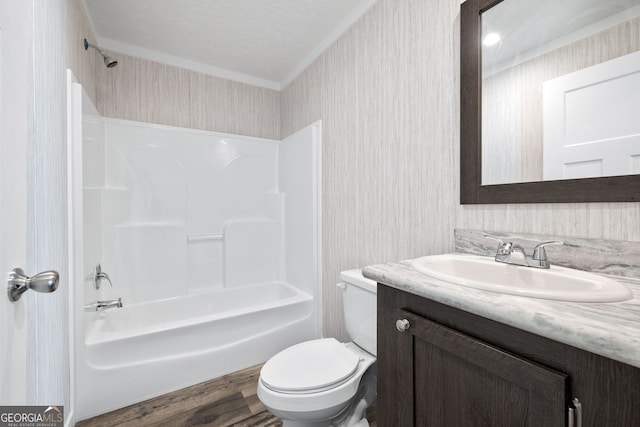 full bathroom with crown molding, toilet, shower / washtub combination, vanity, and hardwood / wood-style flooring