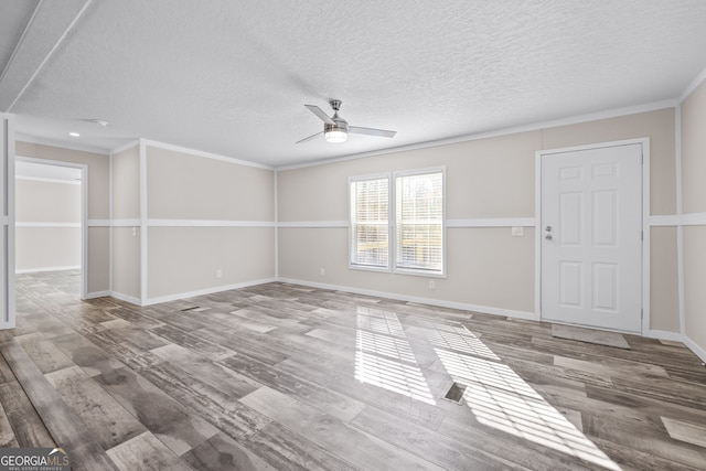 spare room with hardwood / wood-style floors, ceiling fan, ornamental molding, and a textured ceiling