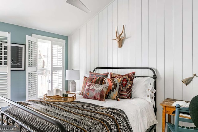 bedroom with wood walls and lofted ceiling