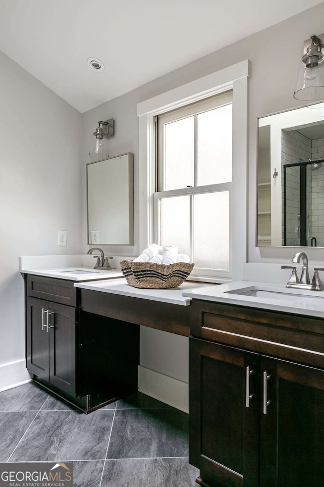 bathroom featuring a shower with door and vanity