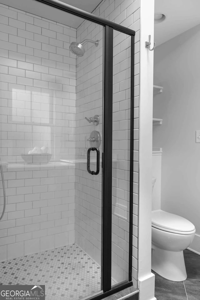 bathroom with toilet and an enclosed shower