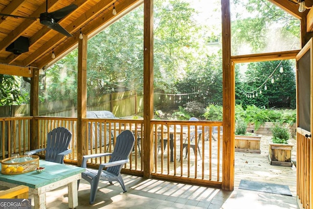 unfurnished sunroom with ceiling fan, wood ceiling, and vaulted ceiling