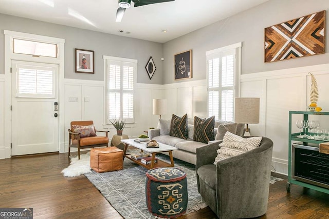 living room with dark hardwood / wood-style flooring, ceiling fan, and a healthy amount of sunlight