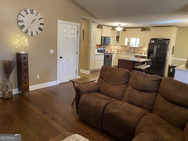 living room with sink, vaulted ceiling, and dark hardwood / wood-style floors