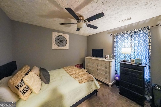 carpeted bedroom featuring ceiling fan and a textured ceiling