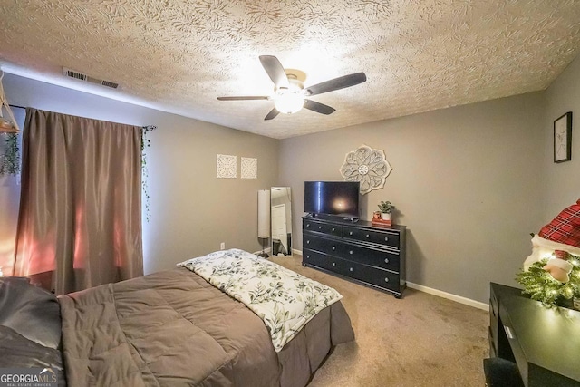 bedroom featuring light carpet, ceiling fan, and a textured ceiling