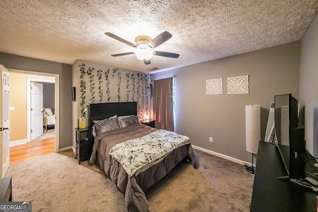 bedroom with light carpet, a textured ceiling, and ceiling fan