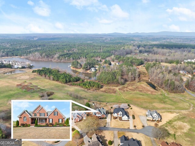 drone / aerial view featuring a water and mountain view