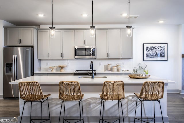 kitchen with gray cabinetry, sink, decorative light fixtures, and appliances with stainless steel finishes