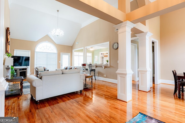 living room with crown molding, high vaulted ceiling, ceiling fan with notable chandelier, and light wood-type flooring