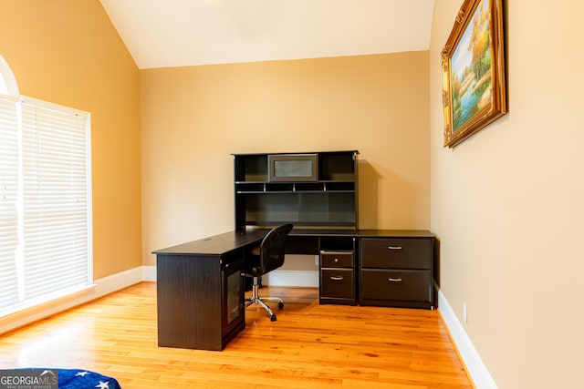 office featuring vaulted ceiling and light hardwood / wood-style flooring