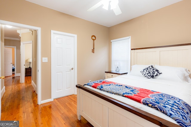 bedroom with light hardwood / wood-style floors, ceiling fan, and ornamental molding