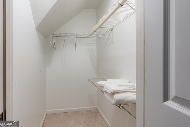 spacious closet featuring light carpet and vaulted ceiling