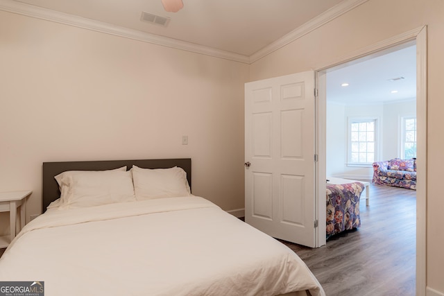 bedroom featuring hardwood / wood-style floors, ceiling fan, and ornamental molding