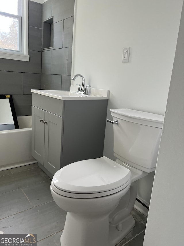 bathroom with a bathtub, vanity, and toilet