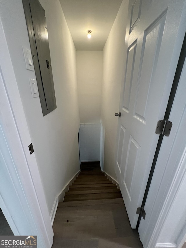 stairway with electric panel and hardwood / wood-style floors