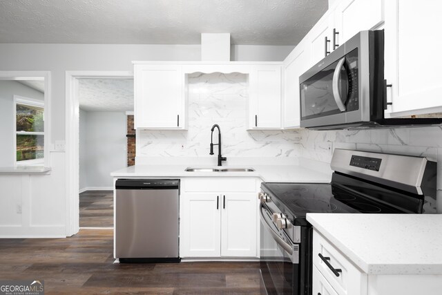 kitchen with sink, a textured ceiling, appliances with stainless steel finishes, dark hardwood / wood-style flooring, and white cabinetry