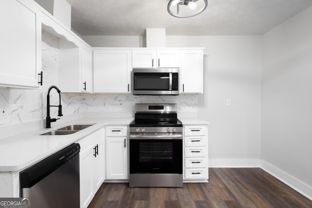 kitchen with dark hardwood / wood-style flooring, white cabinets, stainless steel appliances, and sink