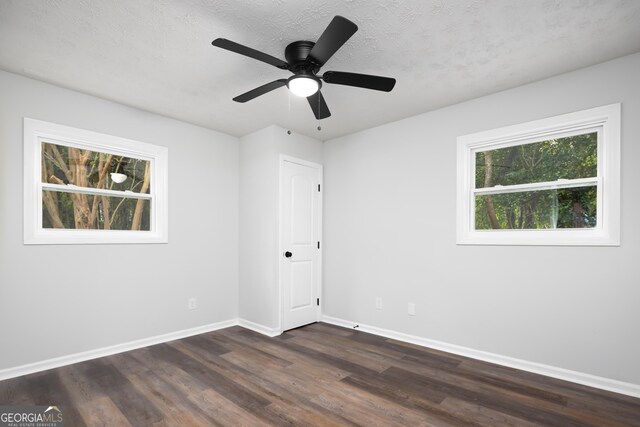 unfurnished room featuring a textured ceiling, ceiling fan, and dark wood-type flooring