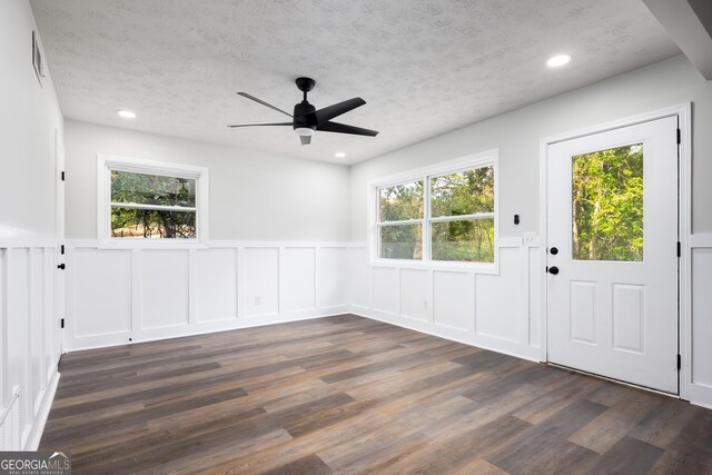 entrance foyer featuring ceiling fan, a healthy amount of sunlight, and dark hardwood / wood-style floors