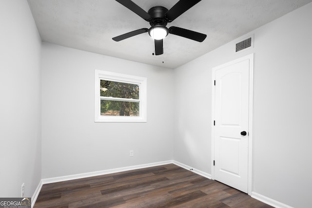 empty room featuring dark hardwood / wood-style floors and ceiling fan