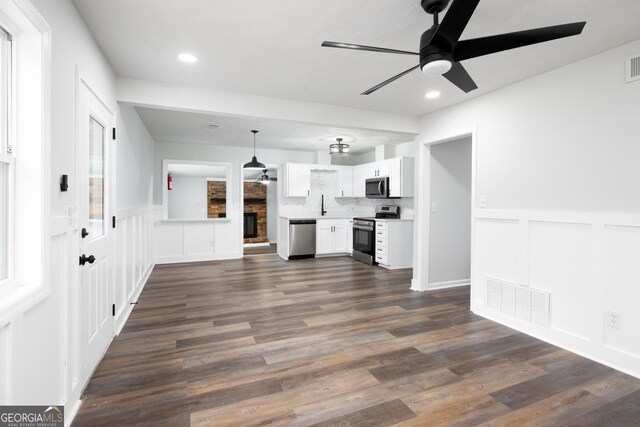 unfurnished living room with ceiling fan, dark hardwood / wood-style floors, and sink