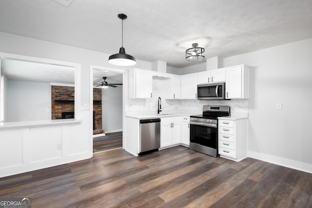 kitchen featuring white cabinets, appliances with stainless steel finishes, and dark hardwood / wood-style floors