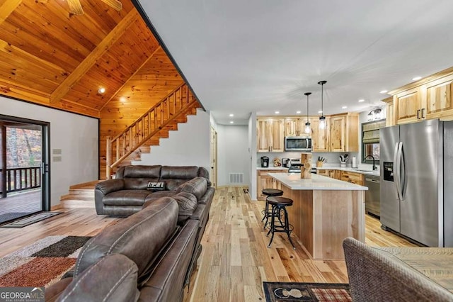 living room with vaulted ceiling, sink, wooden ceiling, and light wood-type flooring