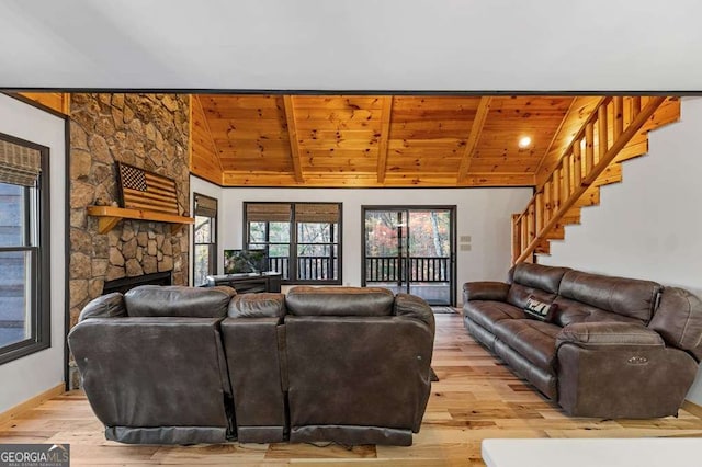 living room featuring vaulted ceiling with beams, wooden ceiling, a fireplace, and light hardwood / wood-style flooring