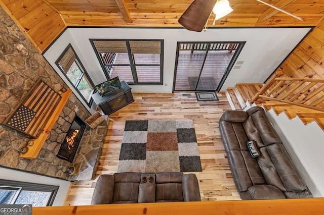 living room with wood-type flooring, wooden ceiling, lofted ceiling with beams, and a healthy amount of sunlight