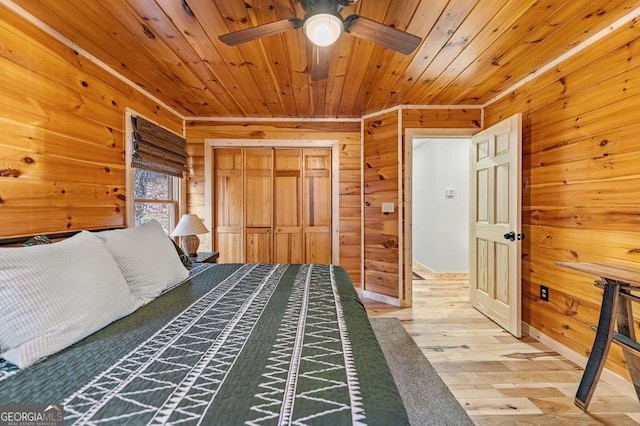 unfurnished bedroom with wood-type flooring, wood ceiling, wooden walls, and a closet