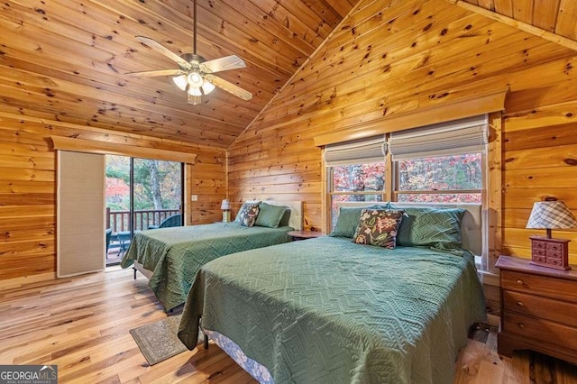 bedroom featuring wood walls, vaulted ceiling, wooden ceiling, access to exterior, and light hardwood / wood-style floors