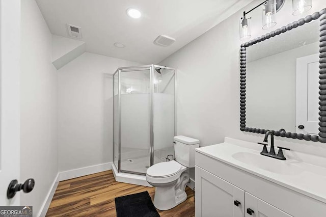 bathroom featuring vanity, hardwood / wood-style flooring, toilet, and walk in shower
